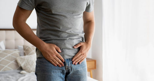 man in gray shirt touching his crotch